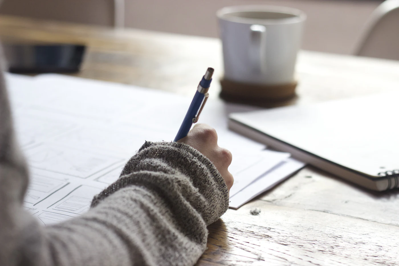 Pen checking items off a checklist notebook beside a book mock-up